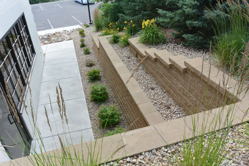 Each side of the renovated building includes terraced retaining walls for plantings to transition from the street to the parking lot. A series of five rain gardens and an infiltration pond were also installed to prevent nearly all runoff from the site from entering the city’s storm drain system.